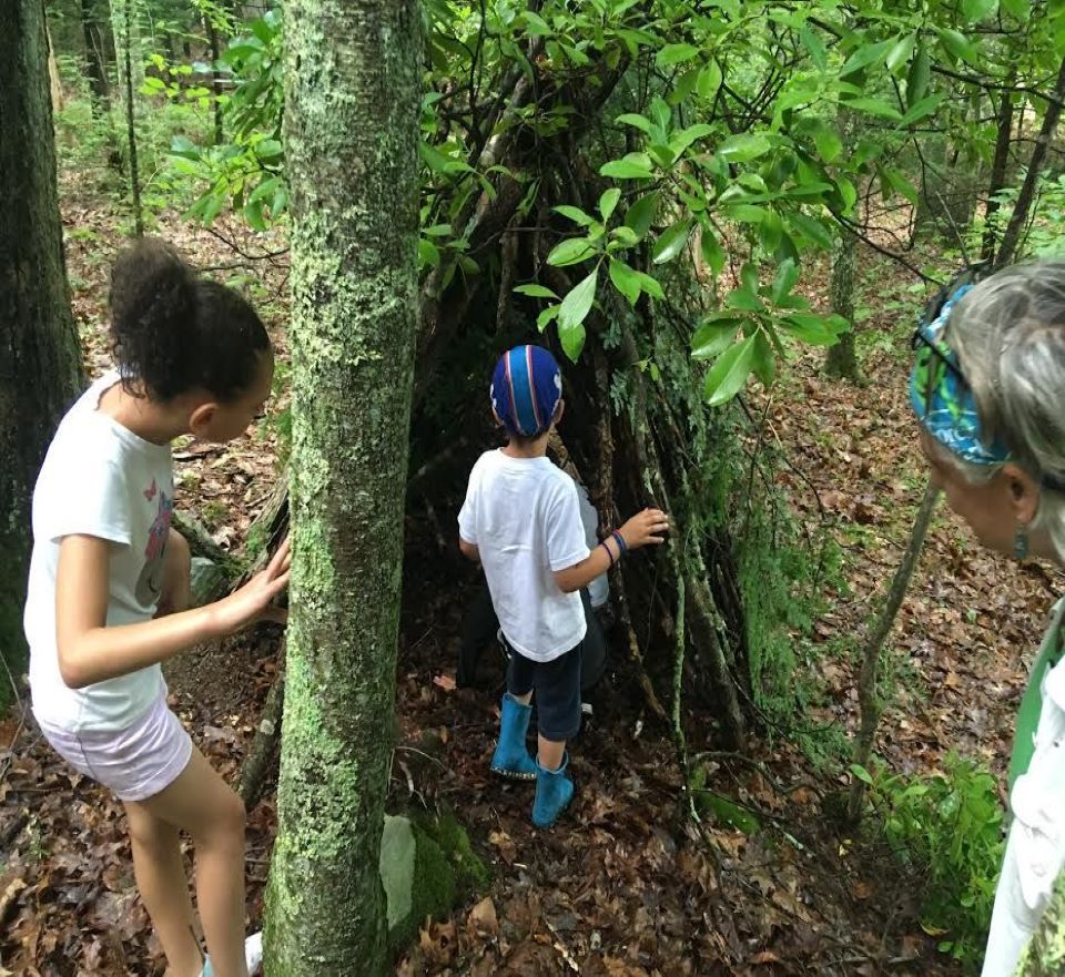 Two children are building an outdoor shelter