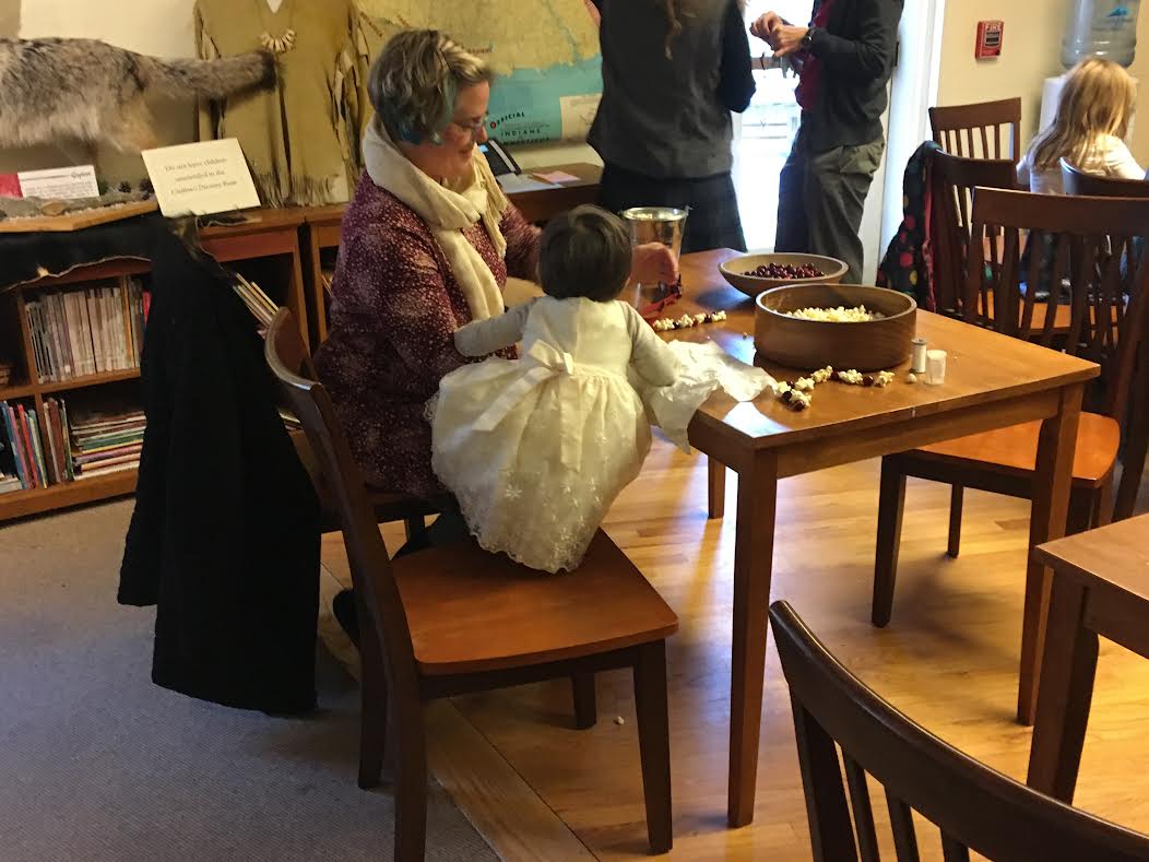 image of small girl and caregiver making a holiday craft together